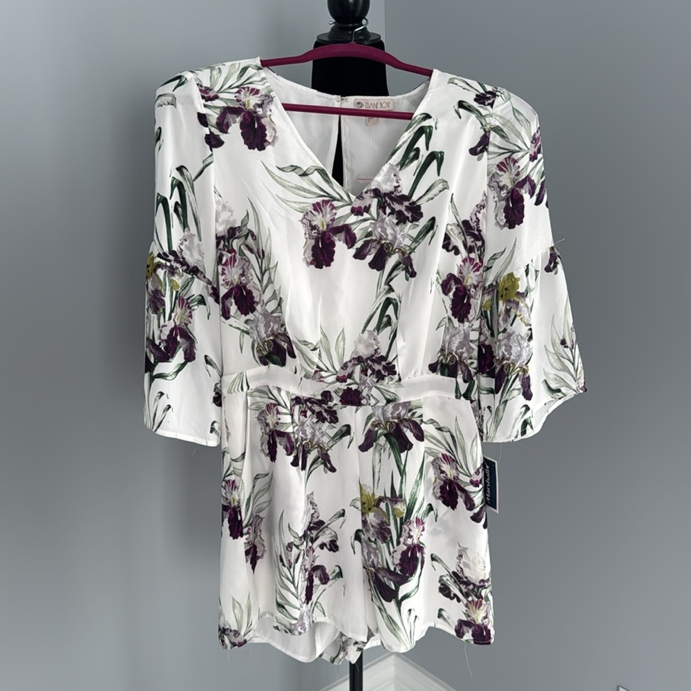 Purple Floral jumpsuit. Size 2. Features pockets and fluted sleeves.